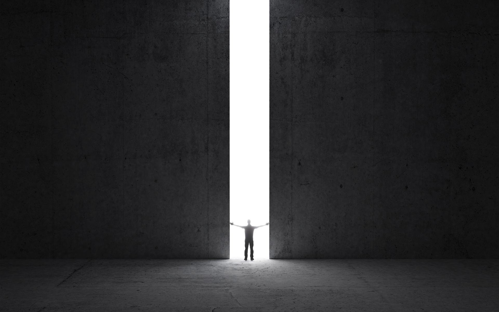 Dark abstract concrete interior. Man stands in the light of opening.